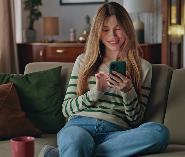 Smiling young woman looking at phone