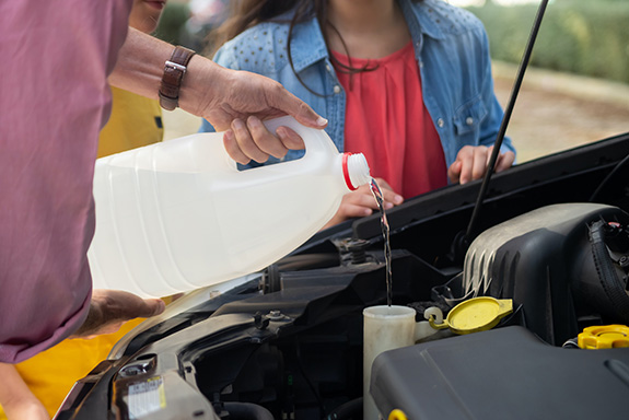 Filling up the windscreen wipers water tank with water and solution
