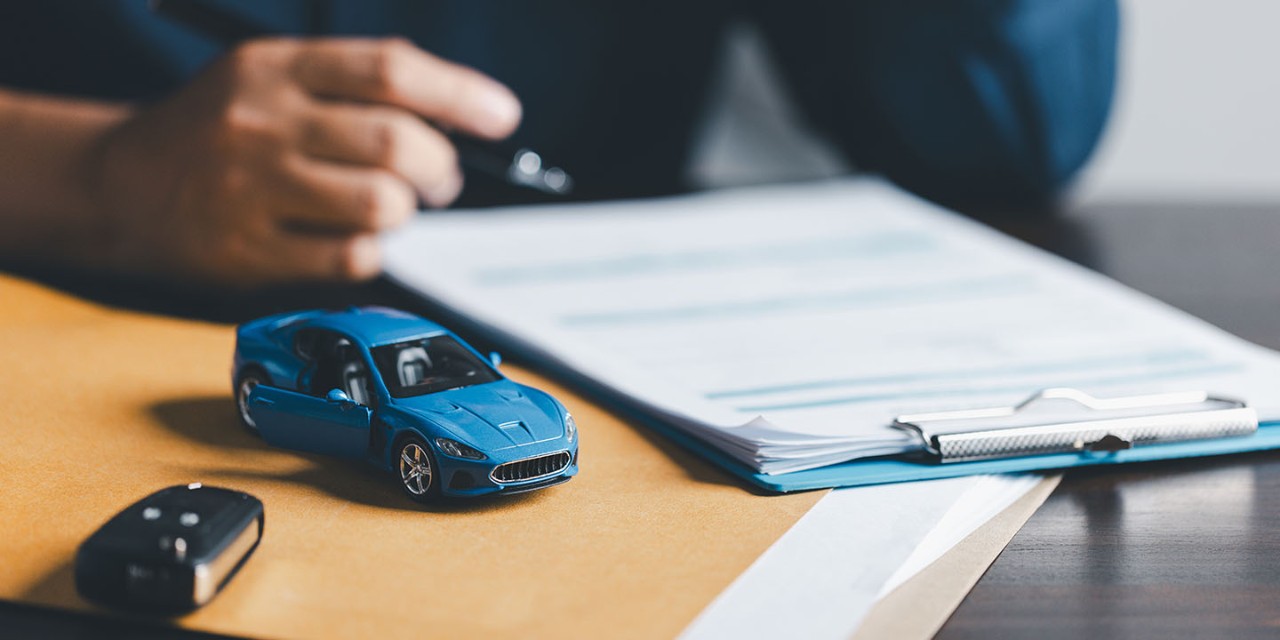Man signing car insurance document contract agreement