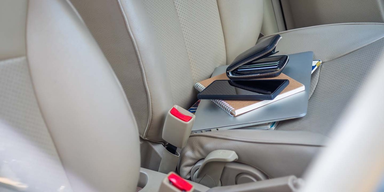 laptop, wallet and mobile phone on a car