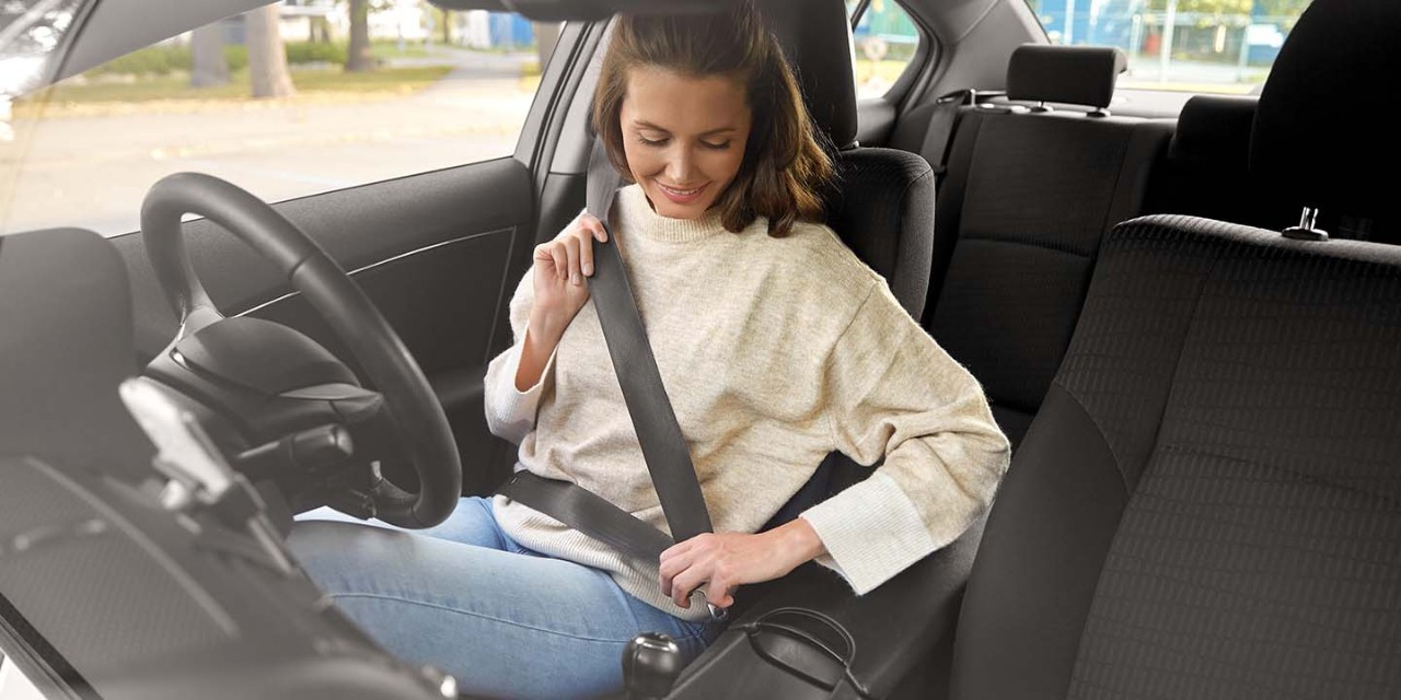  young woman fastening the seat belt