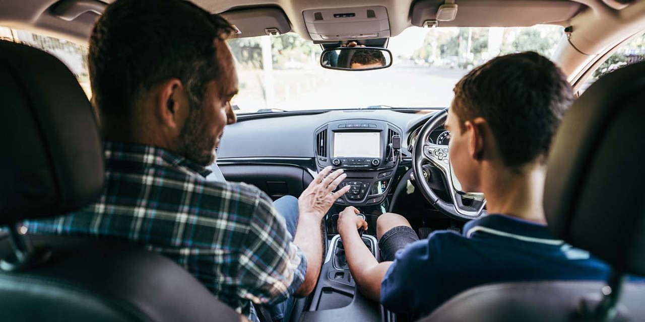  Son and his dad during driving lesson in a car