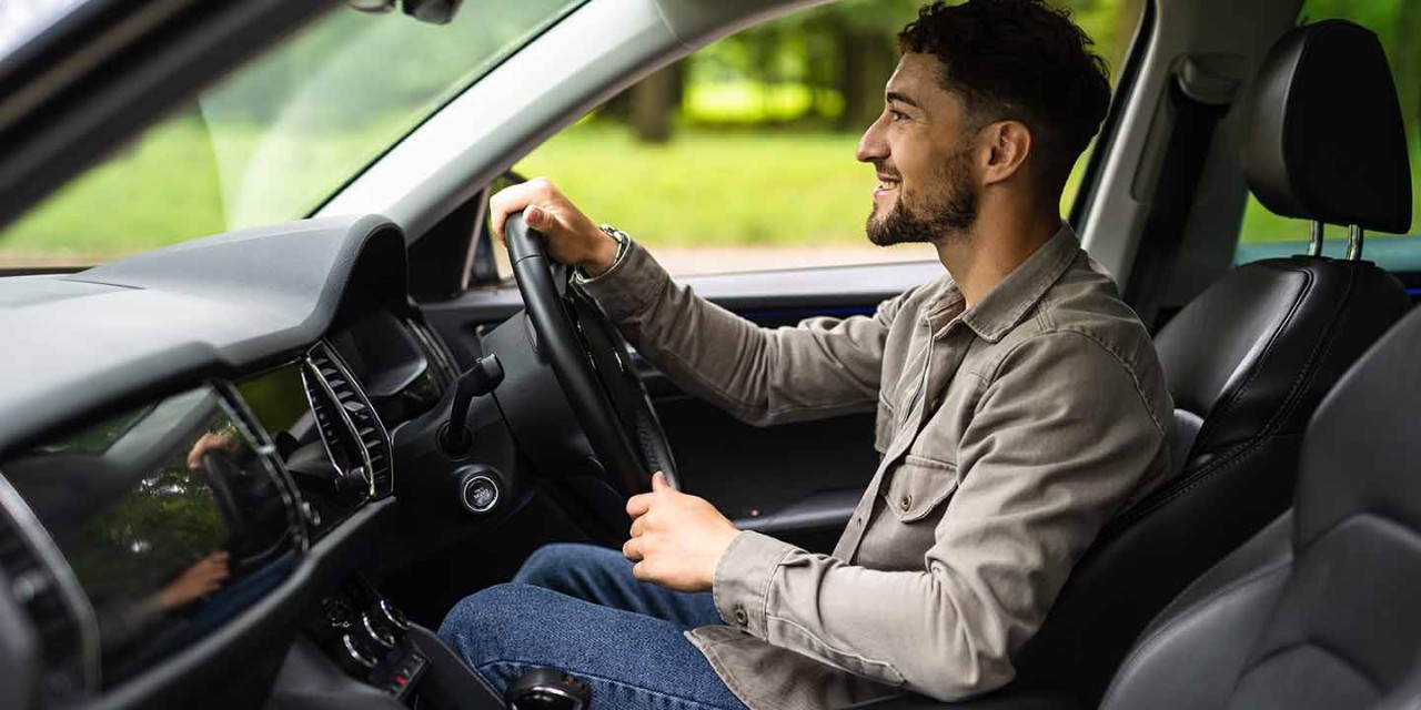smiling young man driving car 