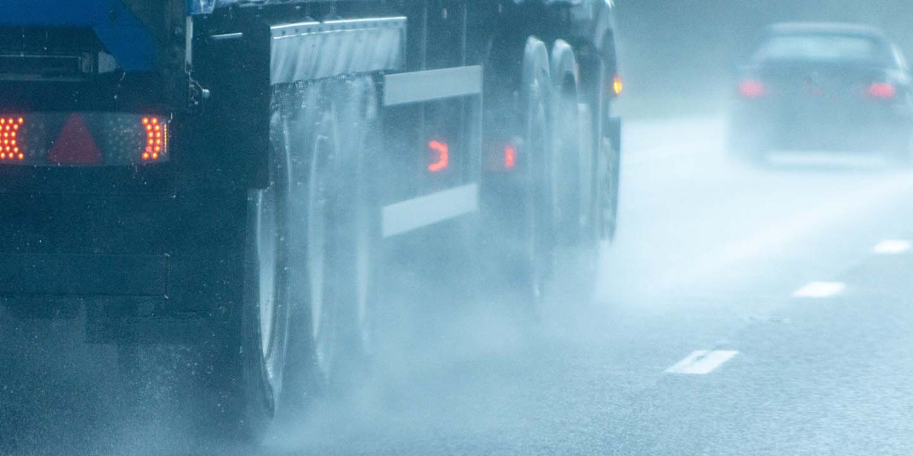 highway with cars in winter with rain fall