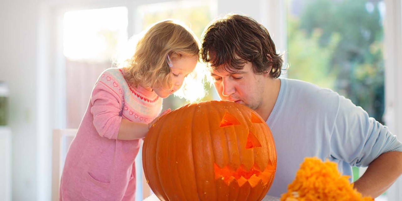 Dad and daughter carving pumpkin 