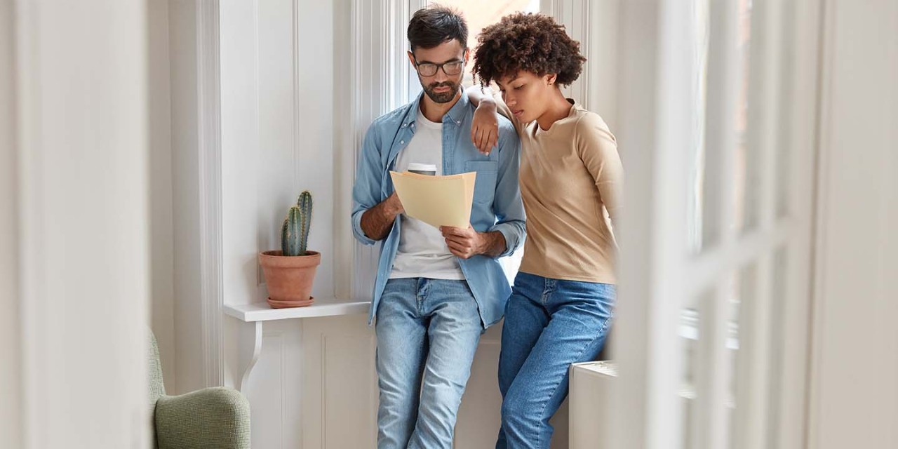  couple looking at the paper on new house