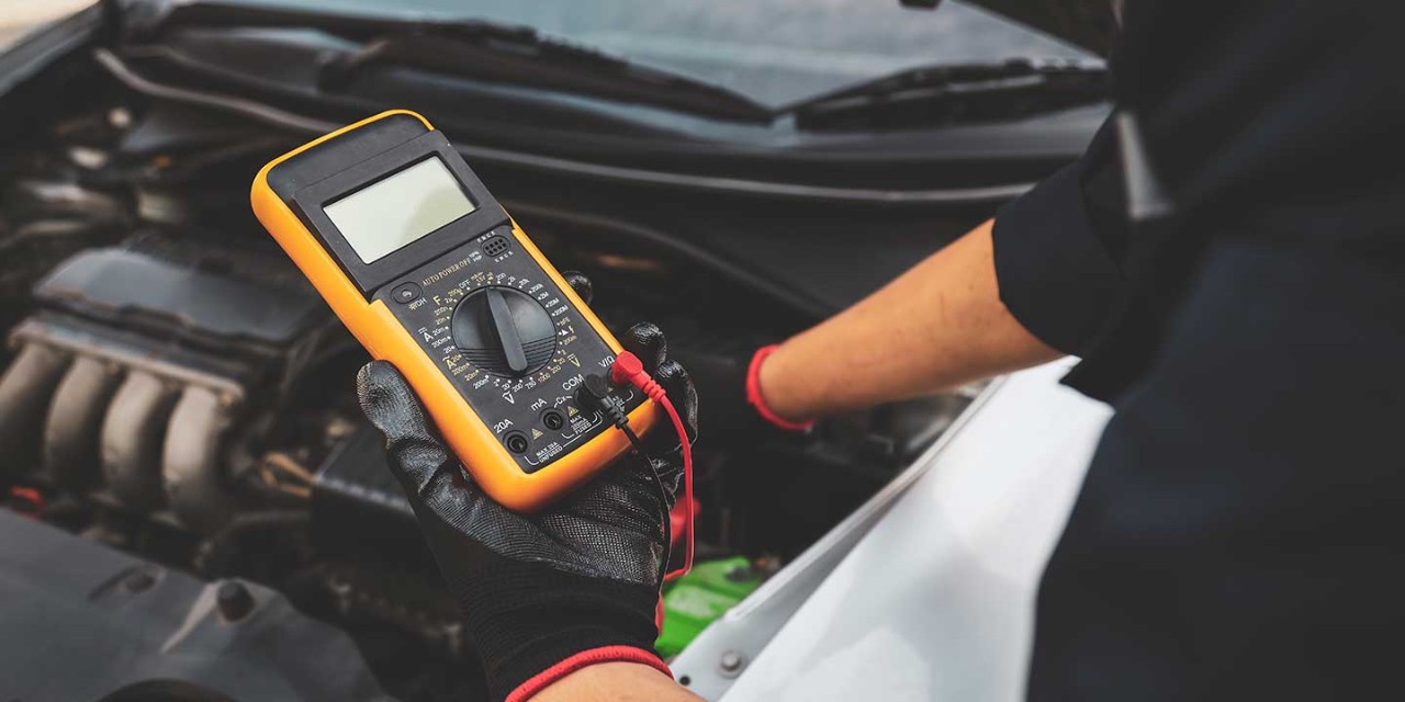 Electrical technician car mechanic use voltmeter to check voltage battery low energy problem