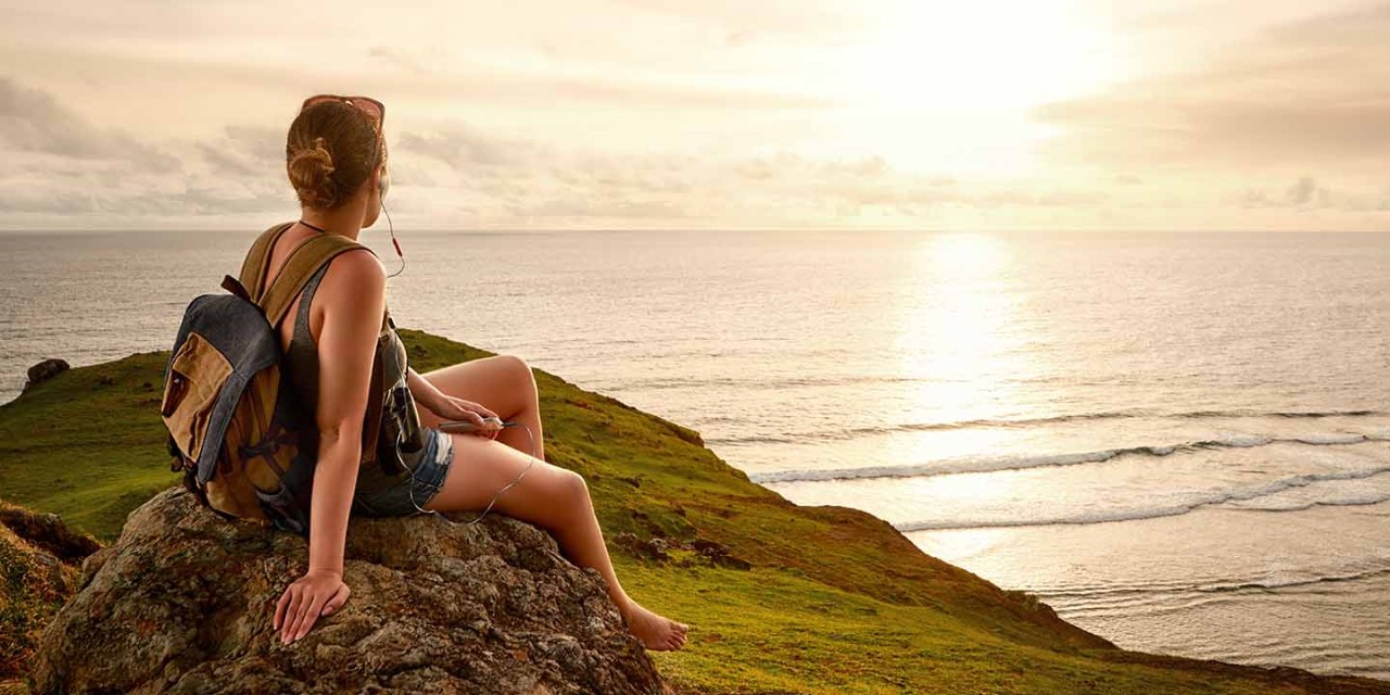  young woman sitting on sea cliff