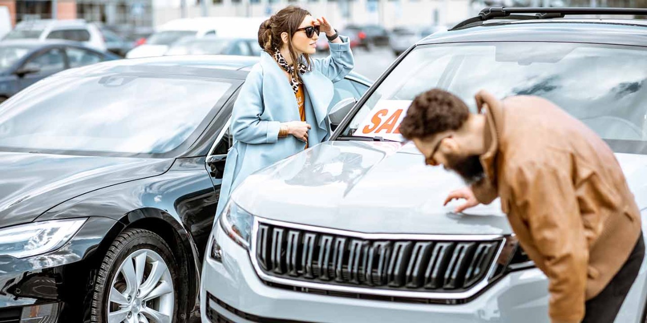 couple checking a car at a dealership
