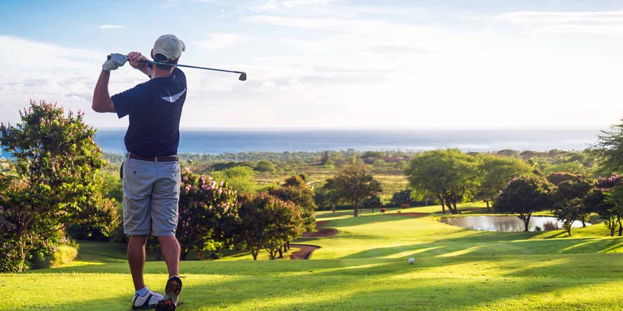 golfer teeing off on golf course