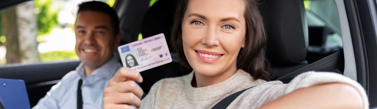  Woman holding a licence while sitting in a car