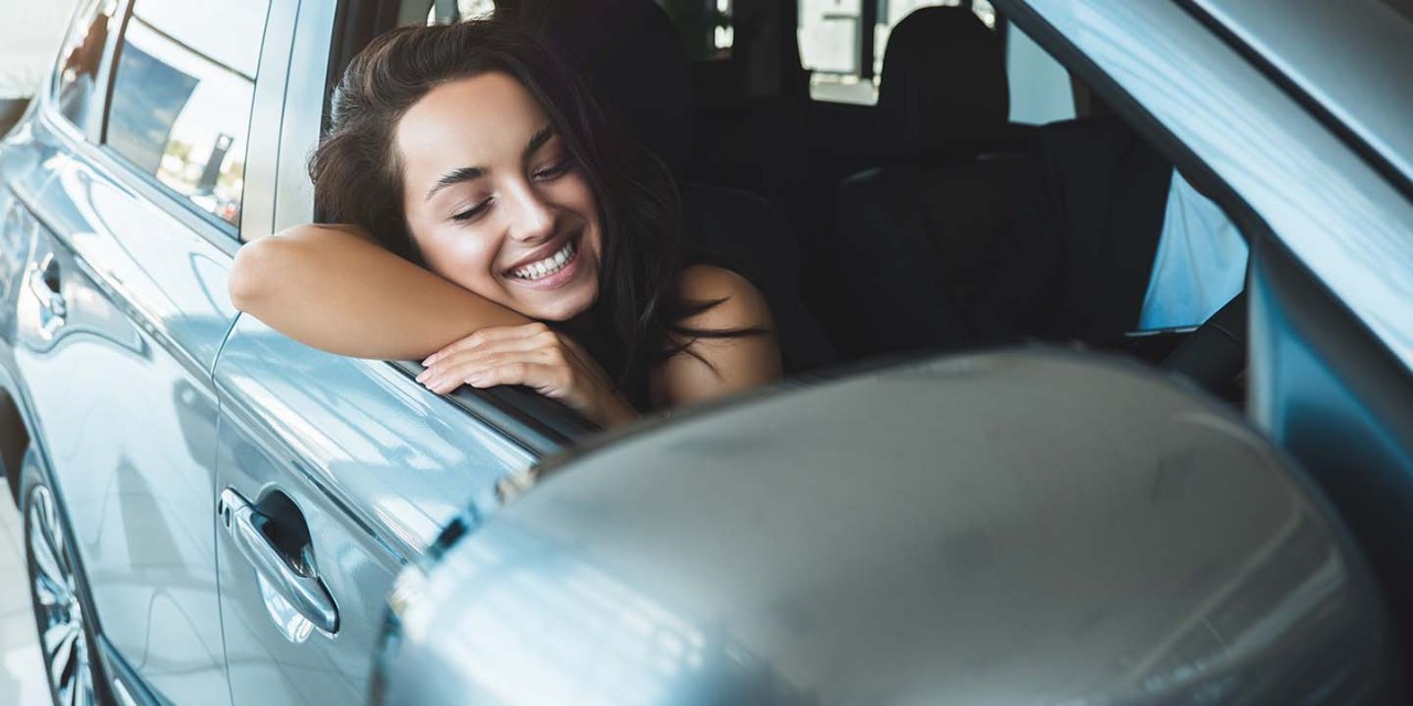 smiling woman driving car 