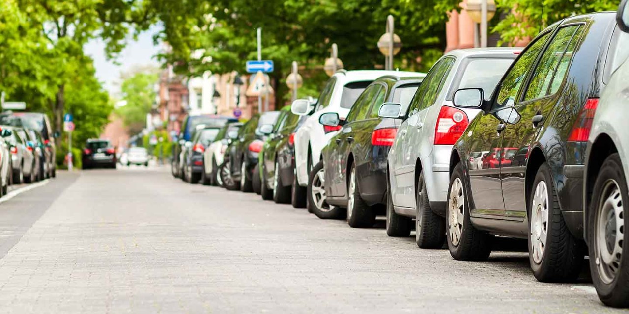 Long row of cars parked in quiet neighbourhood