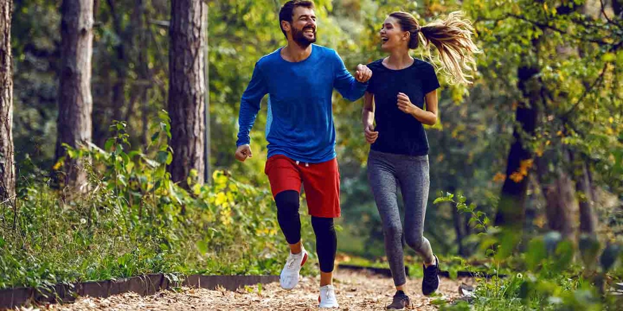  couple running and smiling in the wood
