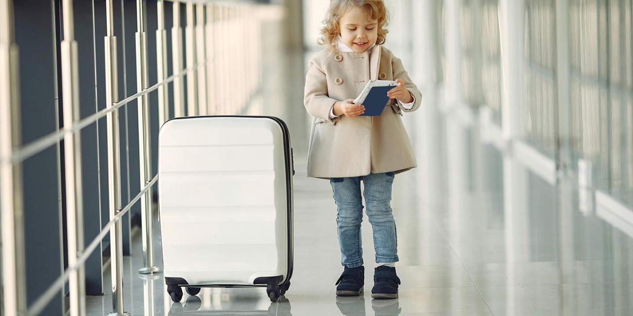  a small girl with suitcase in the airport