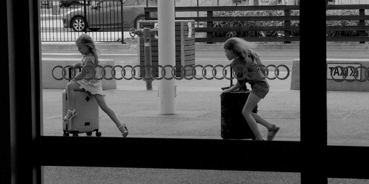  2 girls running with suitcases in the airport