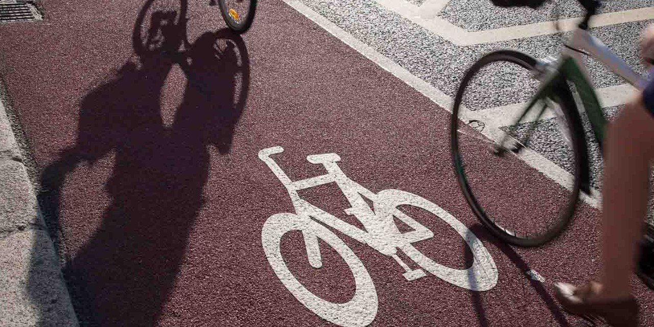  Cyclist riding beside a car