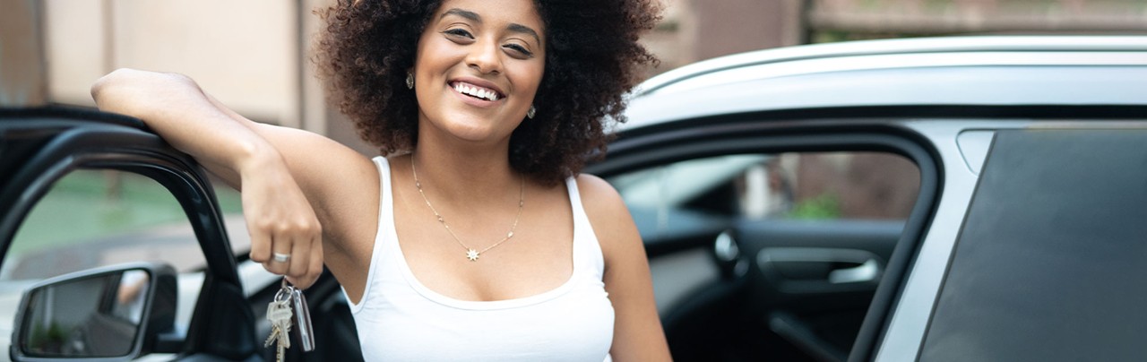 young  girl smiling in front of new car