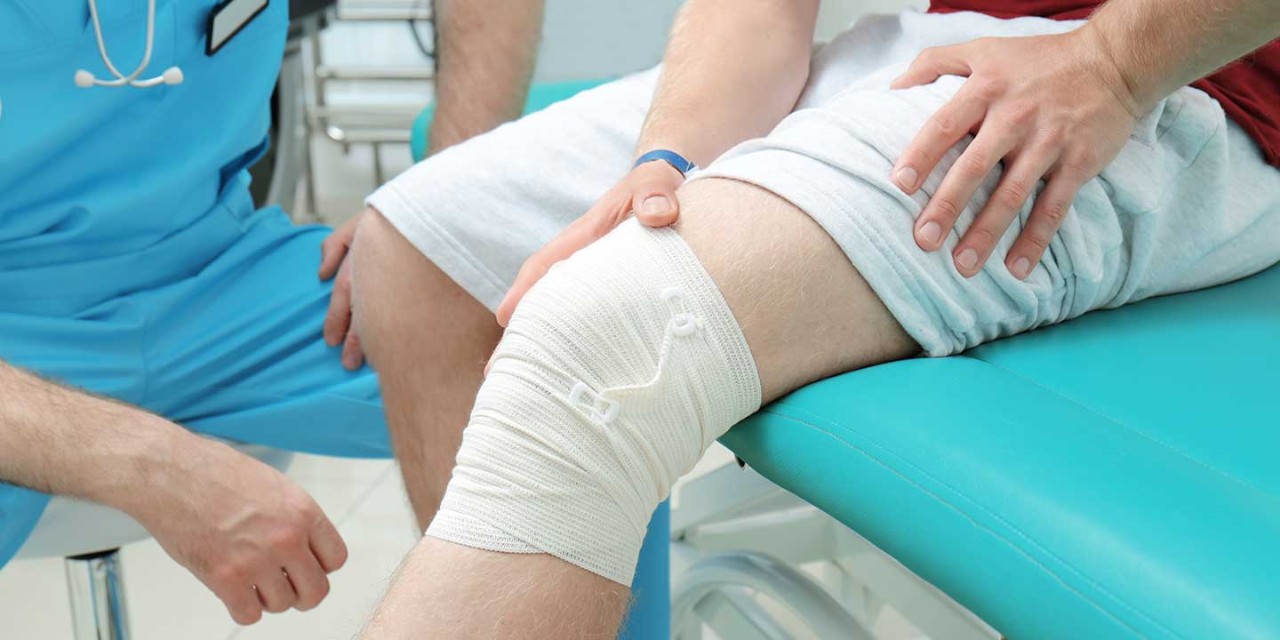 Orthopedist examining patient in clinic