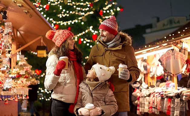 family with takeaway drinks at Christmas market