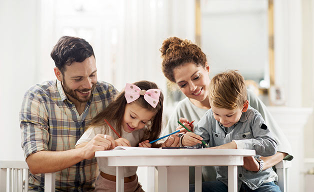 Happy family having fun while coloring together at home.