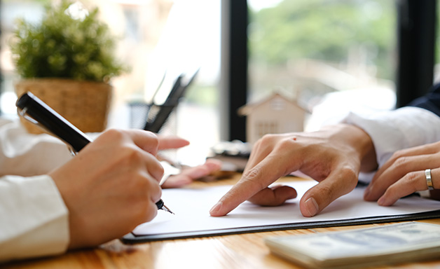 Businessmen hand's pointing where to sign a contract, legal papers or application form.