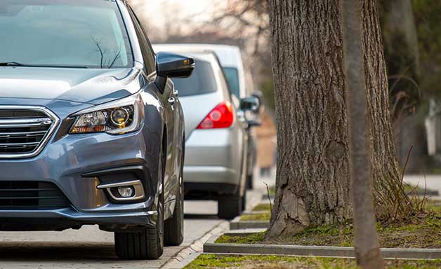 Cars parked in a row on a city street side