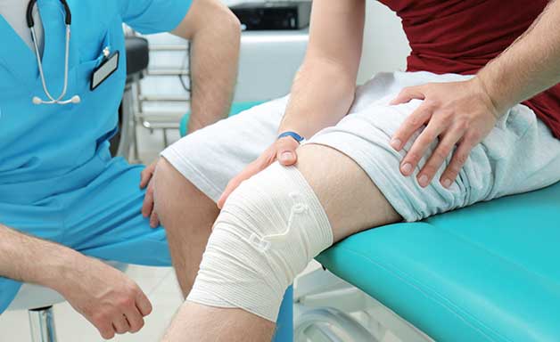 Orthopedist examining patient in clinic