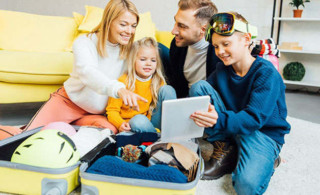 Playful family packing for holiday at home