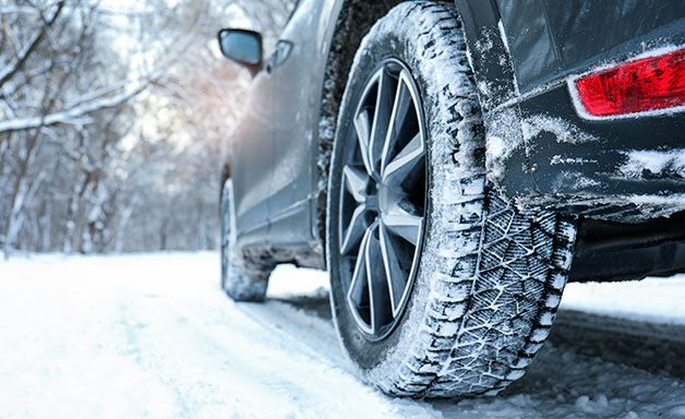 Car tires on winter road covered with snow