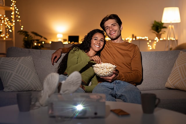 Young couple watching a movie at home